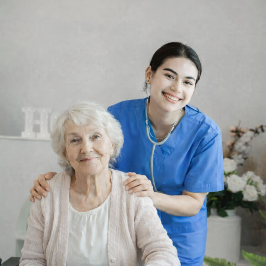 Compassionate hospice care female caregiver smiling and comforting elderly patient in a cozy living room setting
